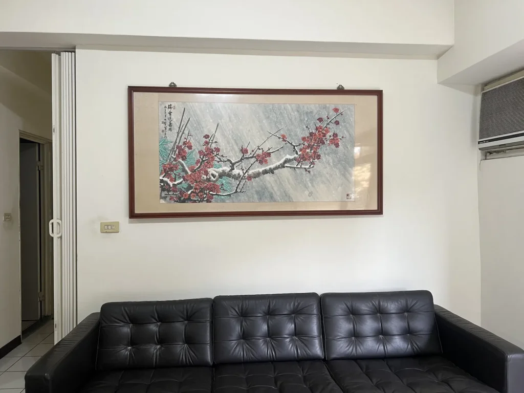 改造前的客廳，原屋主留下的黑色皮沙發與牆上國畫